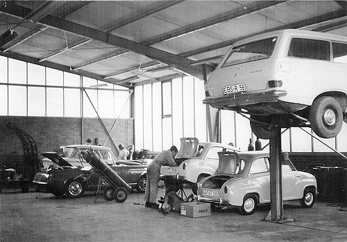 Schwarz-Weiß-Foto: Werkstatt innen mit Oldtimern